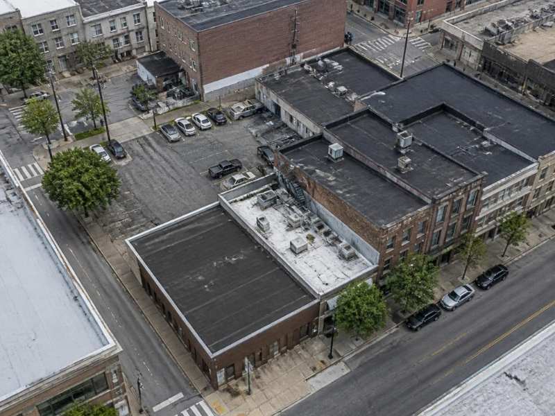 Aerial view of a tight urban infill site in Memphis, Tennessee, with older buildings, paved parking, streets and limited space for drainage.